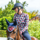Woman riding a horse in an outdoor equestrian setting